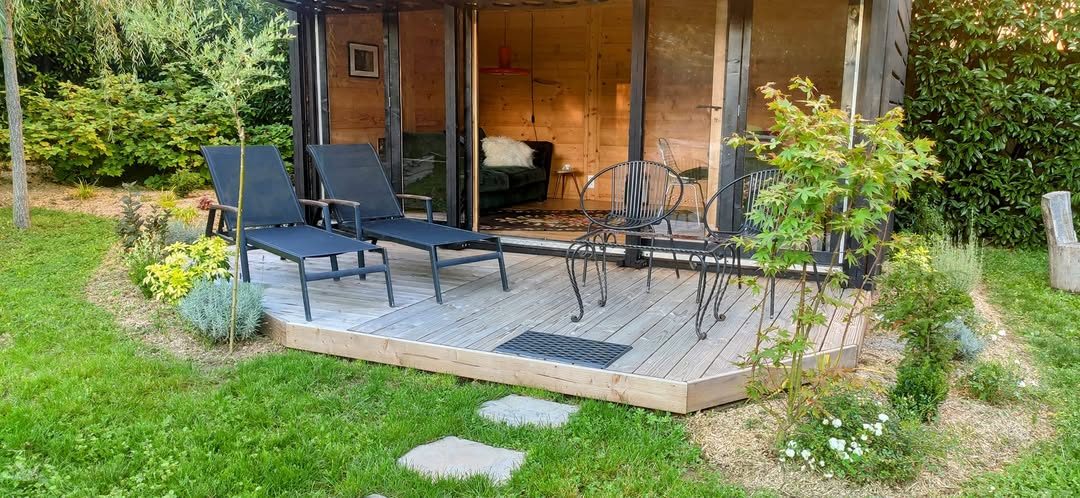 Terrasse en bois devant un abri de jardin