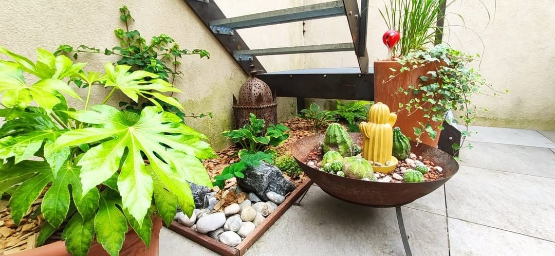 Vasque en acier avec cactées et galets au pied d'un escalier